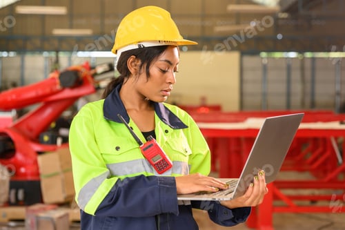 Preview: Professional female mechanical engineer in yellow hard hat and safety uniform