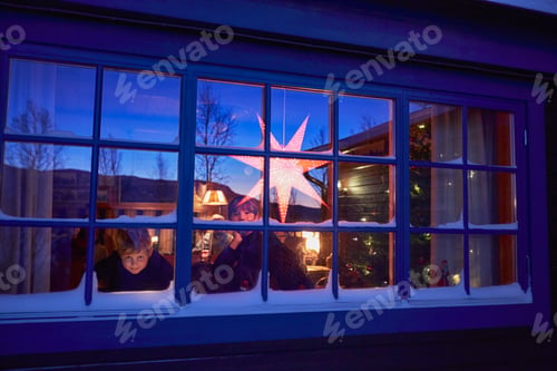 Preview: Two brothers looking out of cabin Christmas window at night