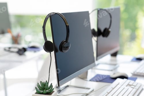 Preview: Computer monitor with empty space for your design and VOIP headset on desk at modern office