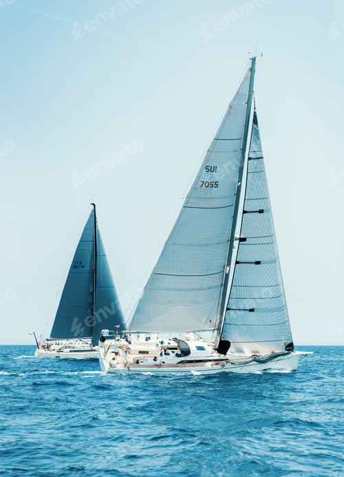 Preview: Sailboats races in regatta near Brindisi under blue sky. Crew members working together on deck