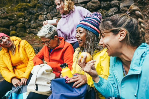 Preview: Multiracial women having fun taking a break after trekking day in mountain forest