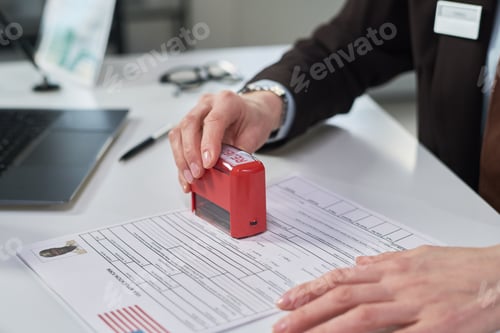 Preview: Woman Stamping Visa Application Form at Visa Center Desk