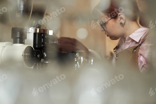 Preview: Young Adult Caucasian Woman Operating Coffee Machine in Cafe Environment