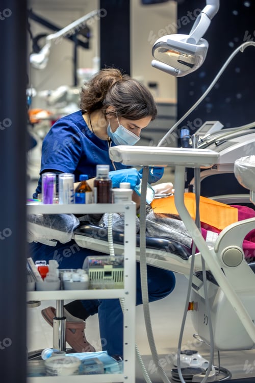 Preview: Young female dentist in dental office. Dentist at work. Dental treatment concept.