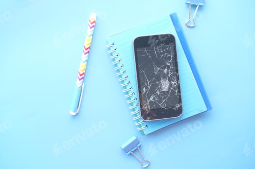 Preview: Top view of broken smart phone and notepad on color background
