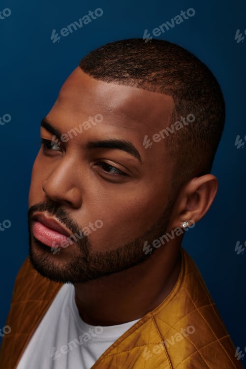 Preview: portrait of stylish young man with diamond earring and beard looking away, fashion concept