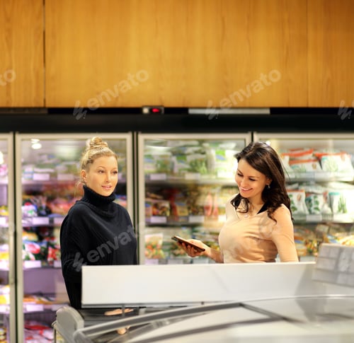 Preview: Two Women Choosing Frozen Food From A Supermarket Freezer