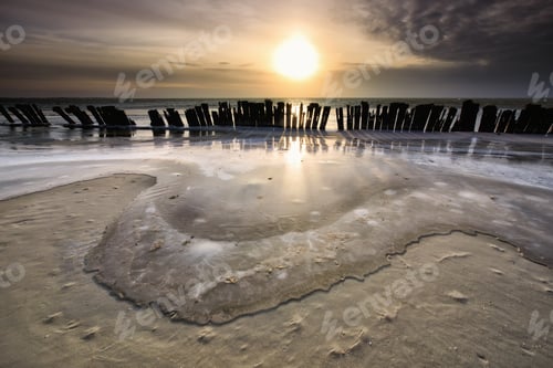 Preview: frozen waves by breakwater at sunset