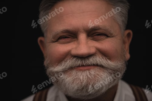 Vorschau: glücklicher älterer Mann blickt isoliert in die Kamera auf Schwarz