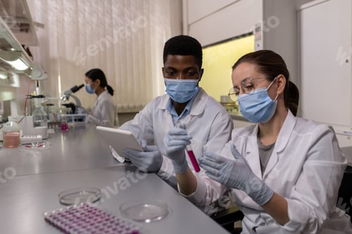 Preview: Scientists examining liquid in test tube
