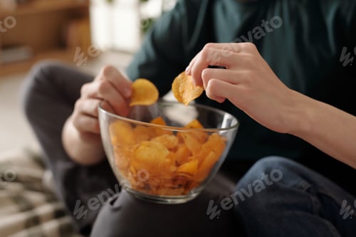 Preview: Female hand taking crusty potato chips