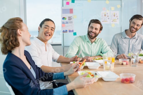 Preview: Smiling business executives having meal in office