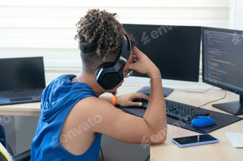 Preview: Worried young man working at home with his computer and headset, making a video call
