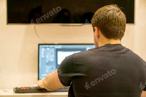 Man Working on Computer at Home, Back View