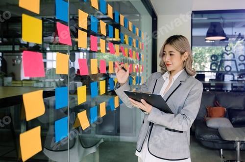 Preview: Secretary working in modern office in skyscraper, writing and sticking adhesive notes