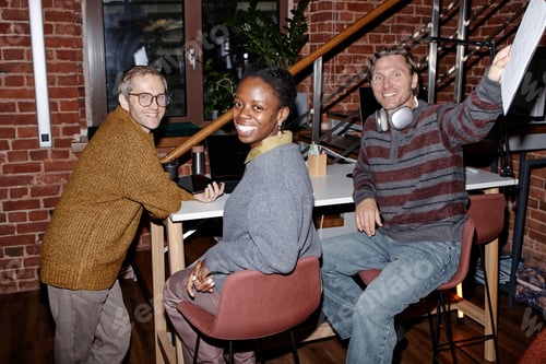 Preview: Multiethnic Young Adults Collaborating and Smiling in Modern Business Office