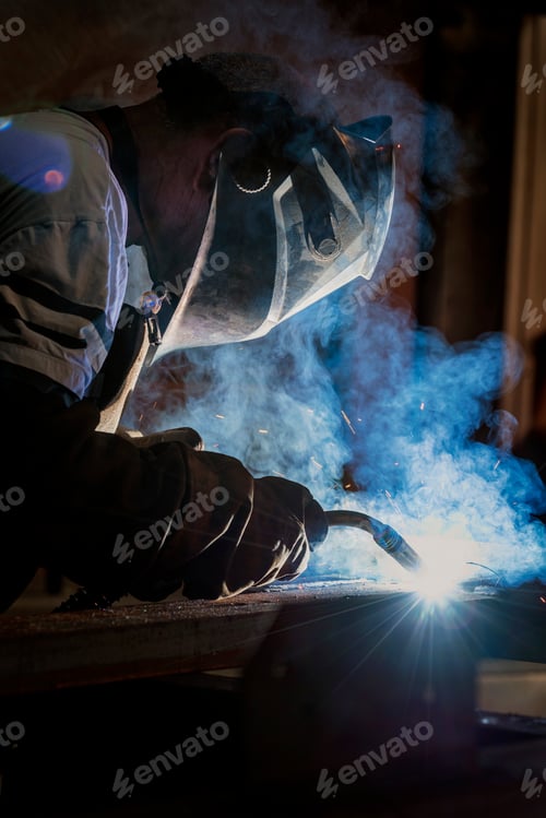 Preview: Welder works with a metal profile, iron construction production.