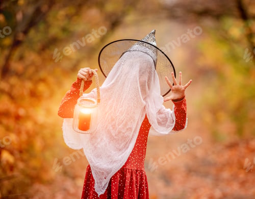 Preview: Little girl in halloween costume with candle