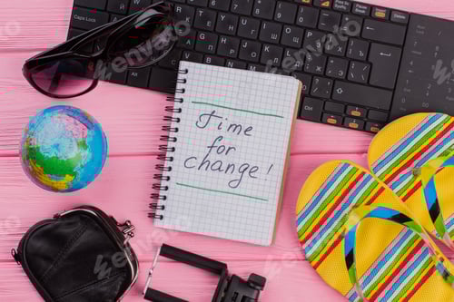 Preview: Time for change on notebook with woman's traveler accessories.