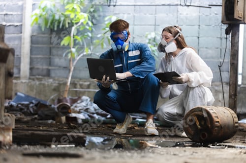 Preview: Team inspector chemical and hazmat wearing protective mask using laptop and write note on clipboard.