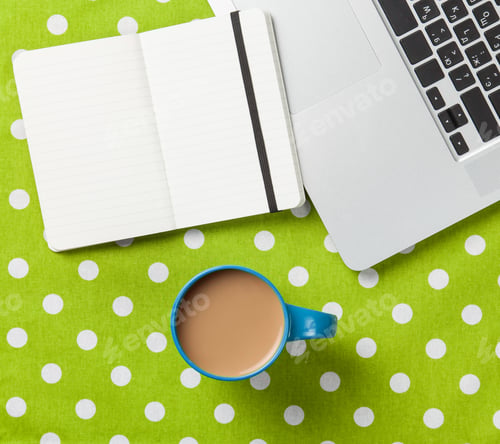Preview: Cup and notebook near laptop comuter