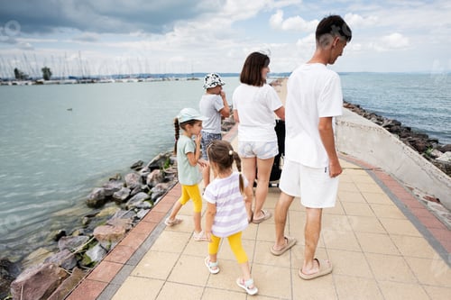 Preview: Family enjoying a seaside walk on a cloudy day at the marina in Siofok, Balaton lake, Hungary.