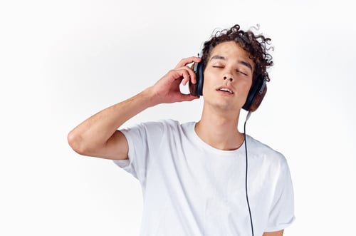 Preview: Cheerful guy with curly hair in headphones music lifestyle