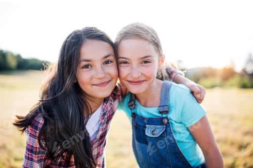 Preview: Two school children standing on field trip in nature, looking at camera