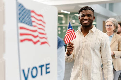Preview: African American man holding American flag vote at polling station. United stated election day