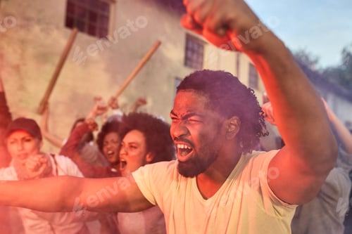 Preview: Angry African American activist protesting with crowd of people on city streets.