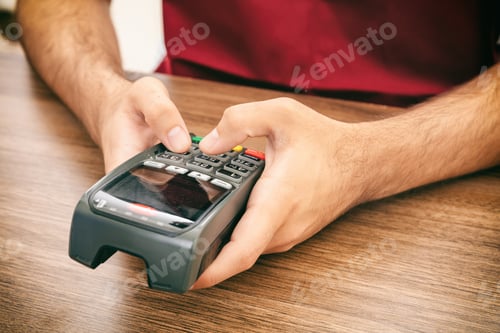 Preview: Man typing on a POS terminal, payment with credit card. Banking, shopping concept.