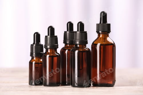 Preview: Bottles of essential oils on table against light background. Cosmetic products