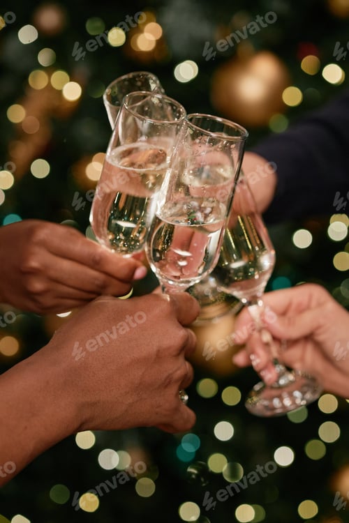 Visualização: Grupo diversificado de jovens adultos tilintando taças de champanhe comemorando juntos