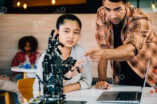 Preview: Teacher helps student construct a robotic arm in classroom design and technology lesson. Fostering