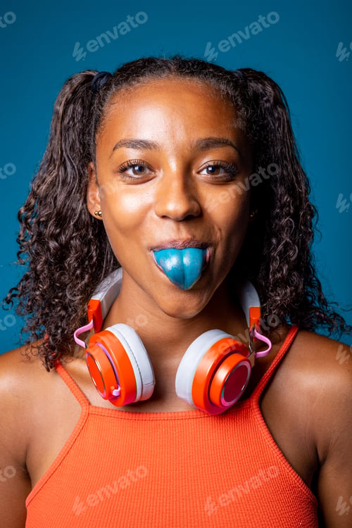 Preview: Woman isolated on background showing blue colored tongue