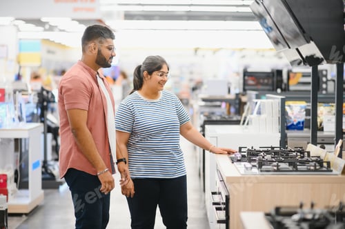 Preview: Young indian couple choosing new gas stove in home appliances store