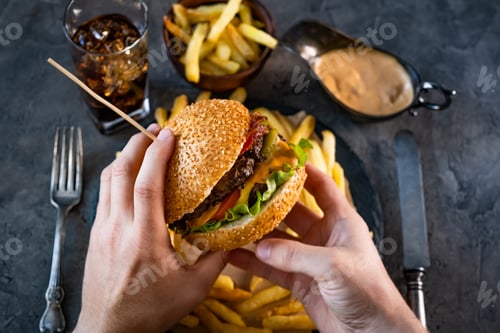 Preview: Male hands holding burger