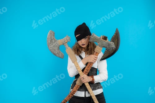 Preview: Young pirate girl holding axes and stand on blue background