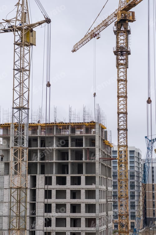Preview: crane and a building under construction against a blue sky background