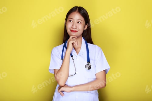 Preview: Beautiful young woman makes a thoughtful expression while wearing a doctor's uniform standing in fro
