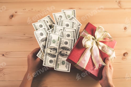 Preview: Money in red bow decorated gift box.
