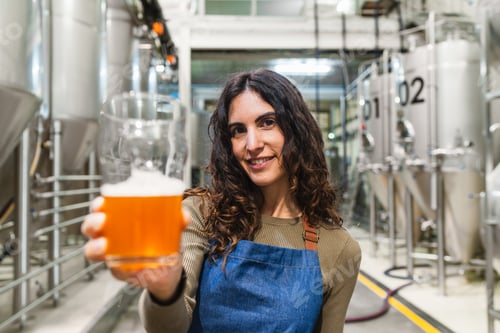 Preview: Woman brewer tasting craft beer in brewery industry