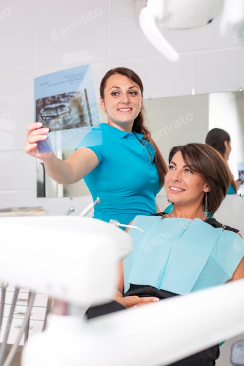 Preview: Dentist and patient are looking at x-ray picture. Check dental health. At the reception at the