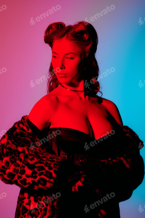 Preview: Chic young woman posing confidently against a vibrant background in a stylish outfit