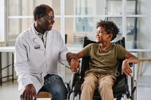 Preview: Smiling Boy in Wheelchair with Caring Doctor