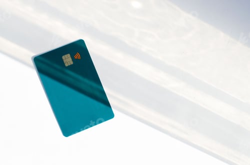 Preview: Closeup of a dark blue credit card isolated on an empty surface