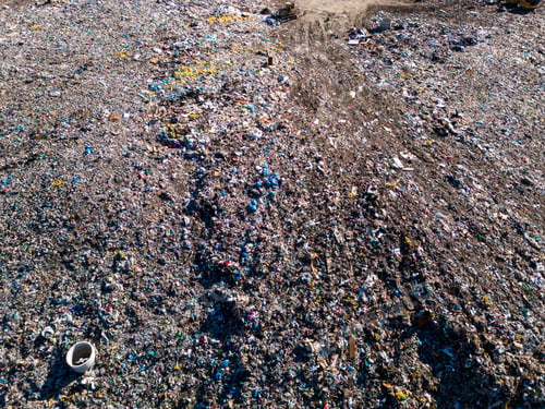 Preview: Aerial view of a vast landfill, where bulldozers are working and trucks are bringing new waste, huge
