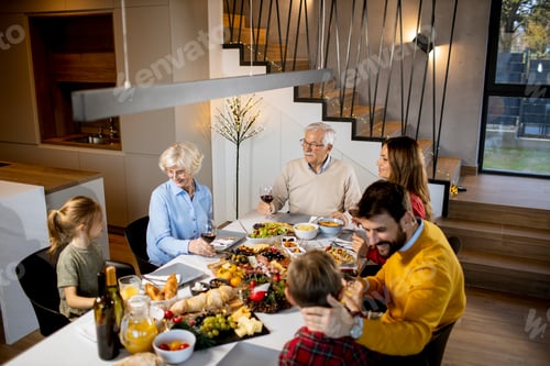 Preview: Happy family having dinner with red wine at home
