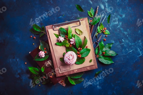 Preview: Meringues or marshmallow in a flower bouquet on a wooden clipboard Tree branch with green leaves and