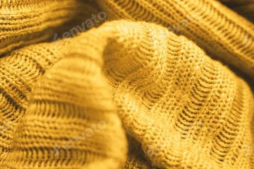 Preview: Close up of yellow knitted textured background.